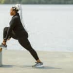 femme de type africain fait du yoga en plein air au bord de la plage avec un legging grande taille confortable