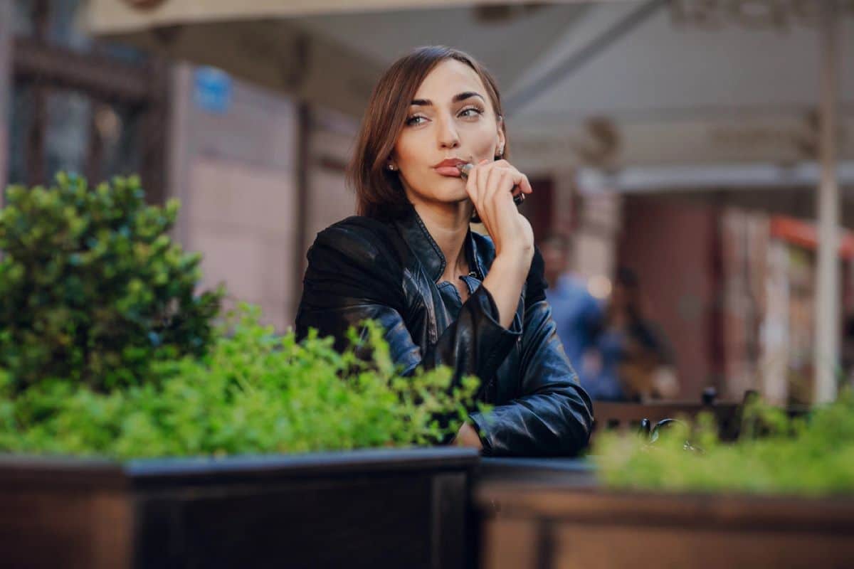 Femme qui fume une cigarette électronique Depositphotos