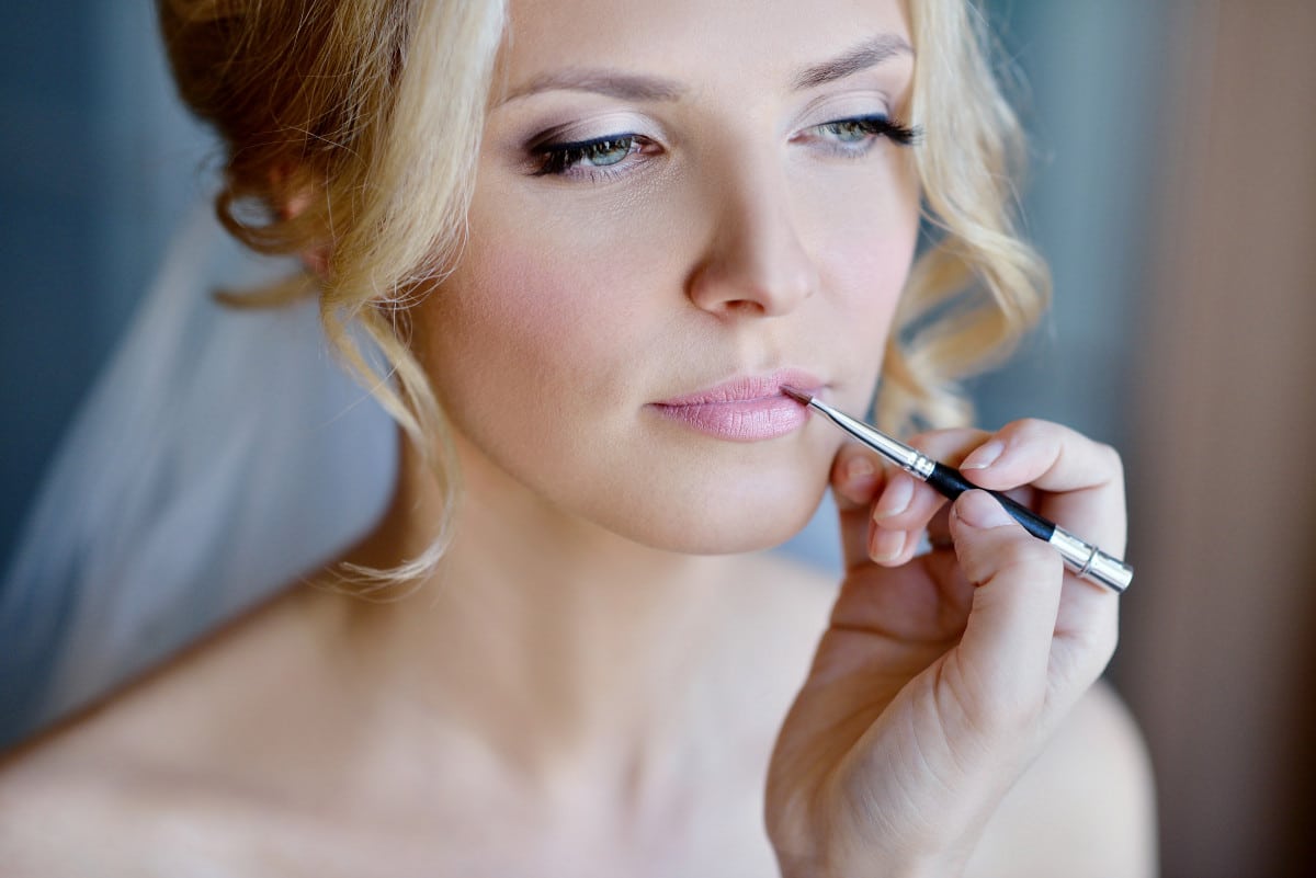 Maquilleuse de mariage réalisant un maquillage pour la mariée