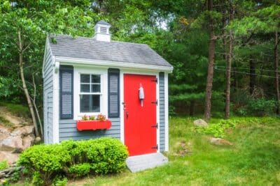 cabane de jardin charmante à fenêtre et porte rouge
