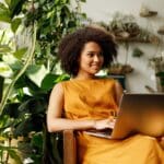 belle femme brune afro se prélasse dans son fauteuil jardin