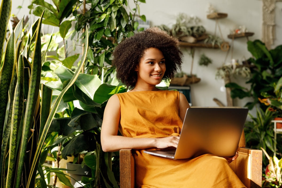 belle femme brune afro se prélasse dans son fauteuil jardin