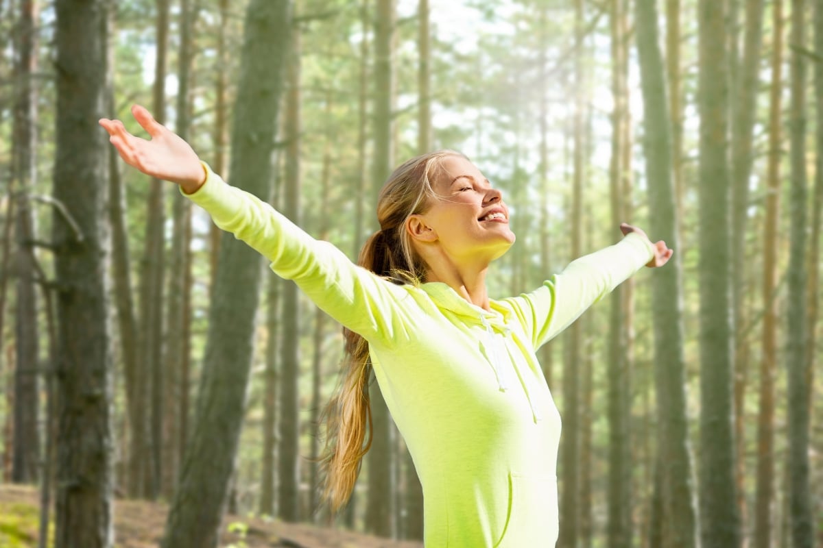 femme qui se détend et se relaxe dans les bois après une séance de sport en été