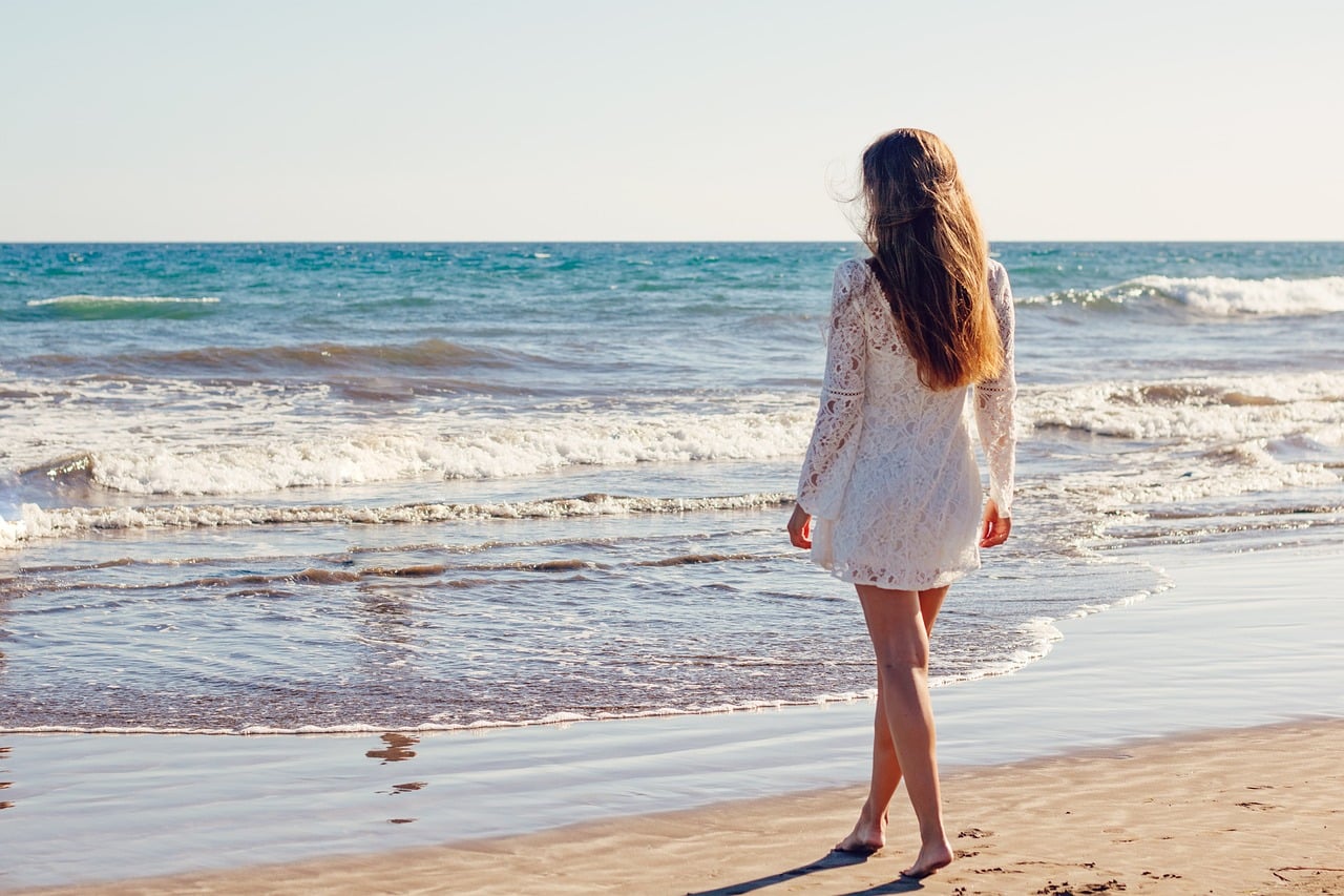 belle femme brune qui prend soin d'elle et se relaxe sur la plage