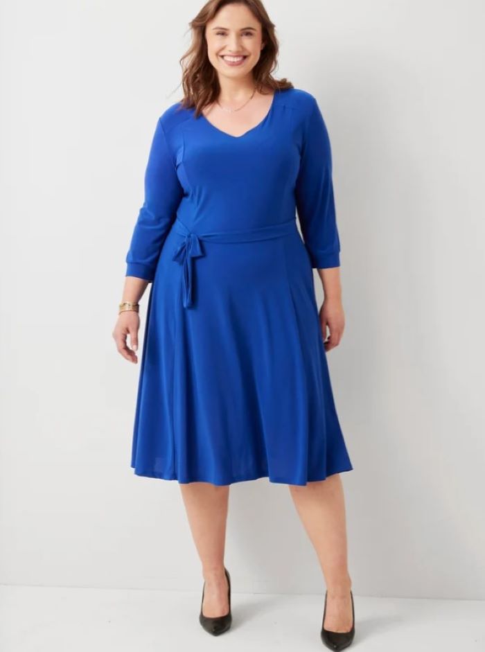 Femme qui porte une robe courte ceinturée grande taille