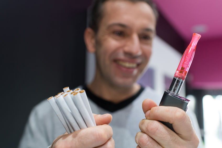Homme choisissant une cigarette electrique contre des cigarettes classiques