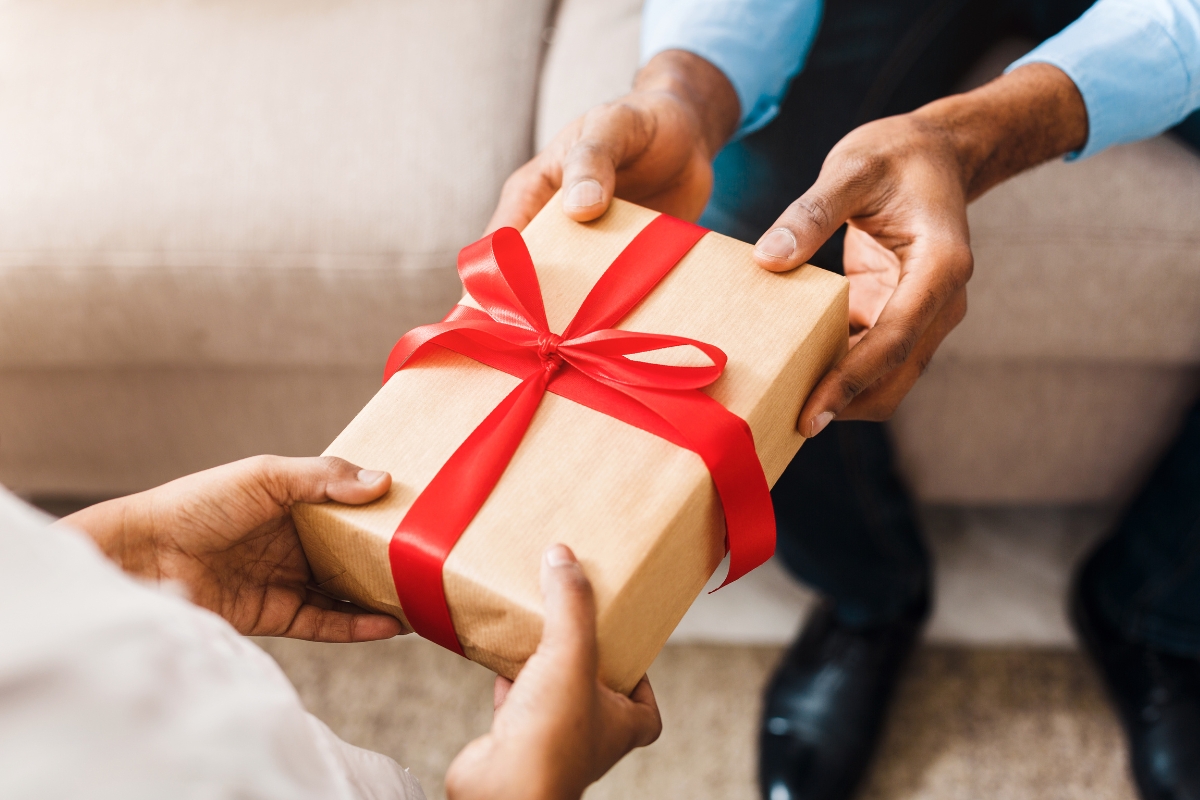une fille qui offre un cadeau à son père