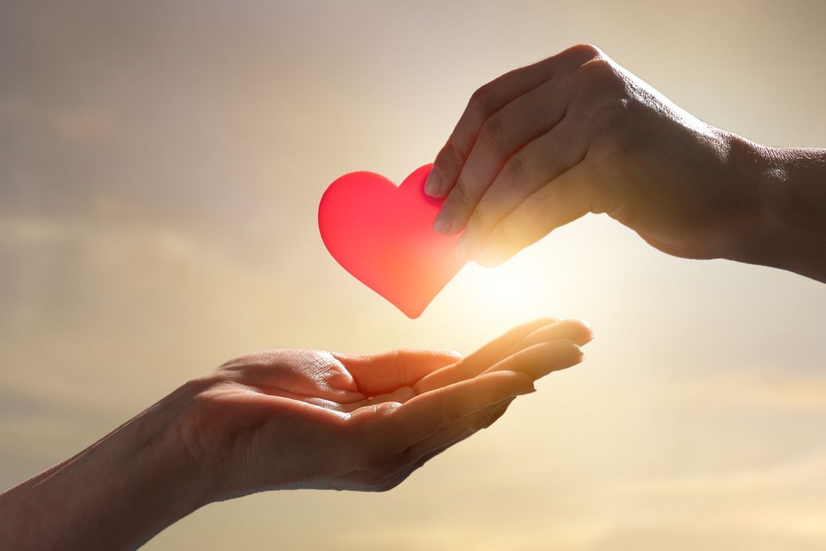 une main qui donne un coeur à un autre main, symbolisant l'amour éternel