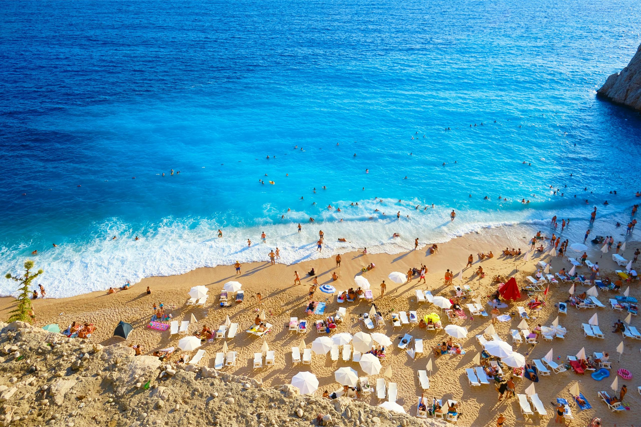 une plage vue du haut avec des vacanciers profitant de la mer