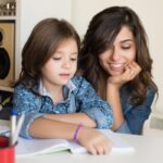 une maman fait les devoirs avec son enfant