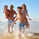 une famille joue au bord de l'eau sur la plage, activités, moments de joie