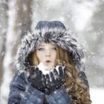 Une belle femme rousse en vetements dhiver en manteau sous la neige dhiver