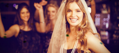 une femme future mariée au premier plan très heureuse et souriante en pleine bachelorette party evjf , avec ses copines qui font la fete au second plan