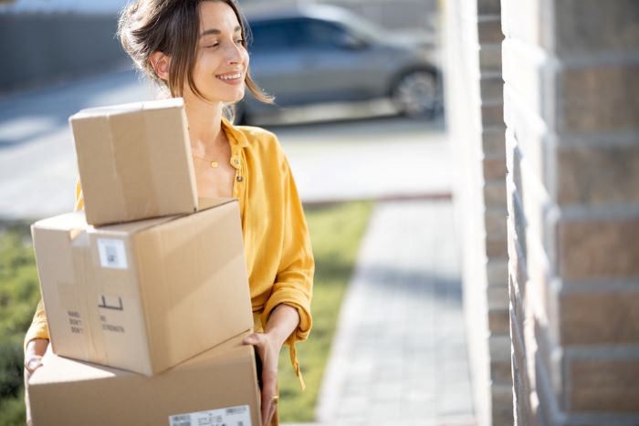 Une jeune femme ravie de recevoir ses colis de vente privees 
