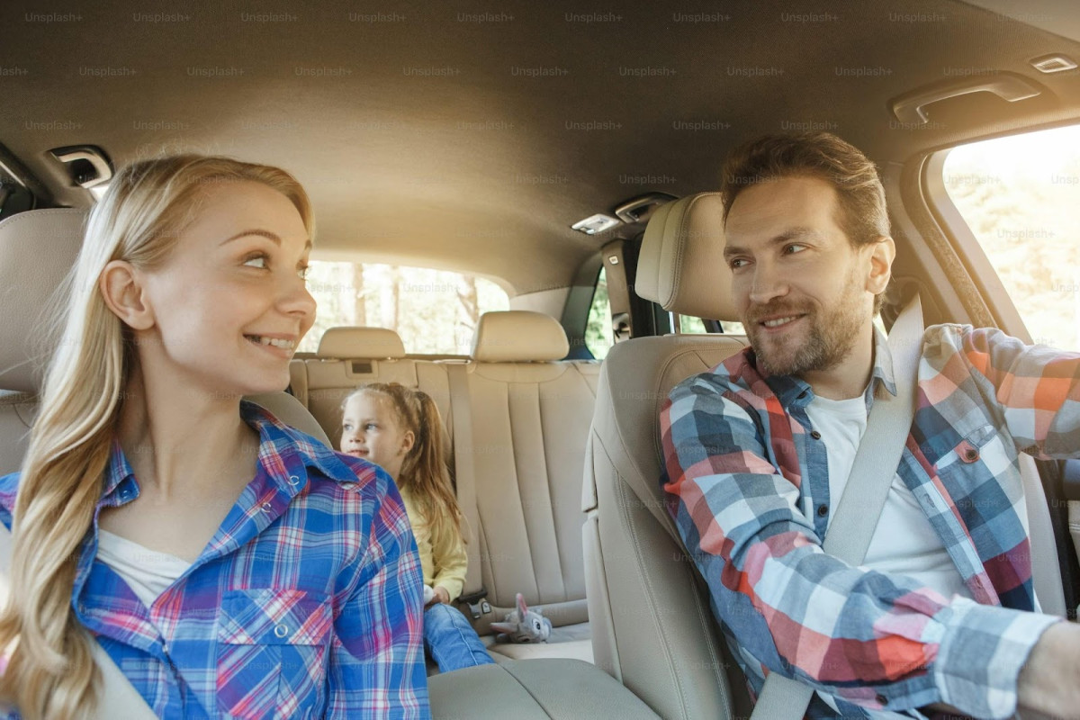 Un couple.avec enfants heureux dans leur voiture de location pour aller en vacances