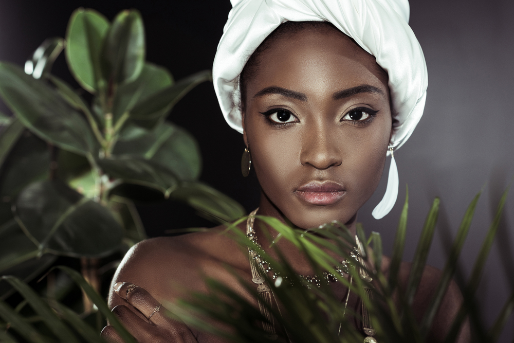 Portrait d’une femme élégante au teint mat et turban blanc — mise en beauté chic et regard graphique