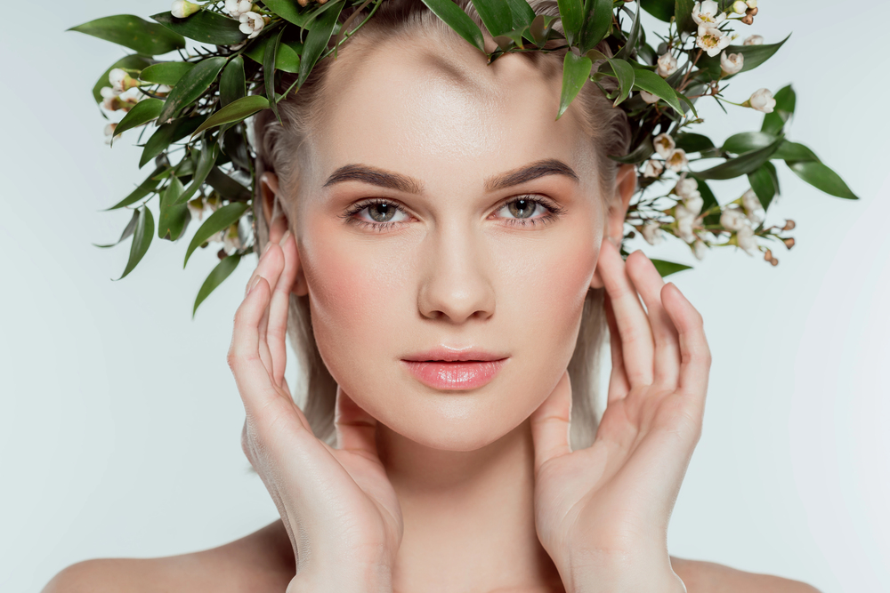 Femme au teint lumineux et couronne florale — maquillage naturel et soin de la peau bio tendance 2025