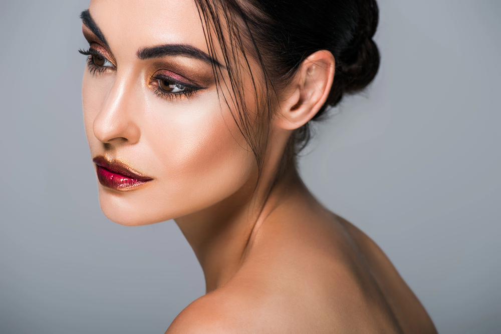 Maquillage glamour 2025 avec lèvres bordeaux métalliques et yeux charbonneux sur peau éclatante