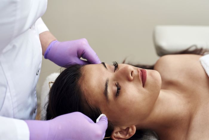 Une femme qui est dans un centre medical et esthetique pour traiter les taches brunes 
