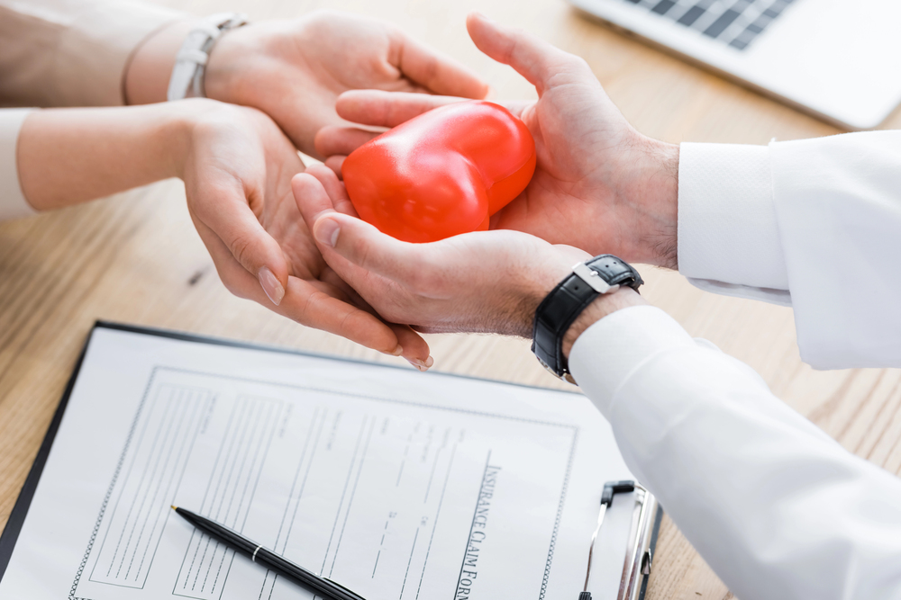 Consultation médicale avec un cœur dans les mains, image forte de la prévention santé et du suivi médical