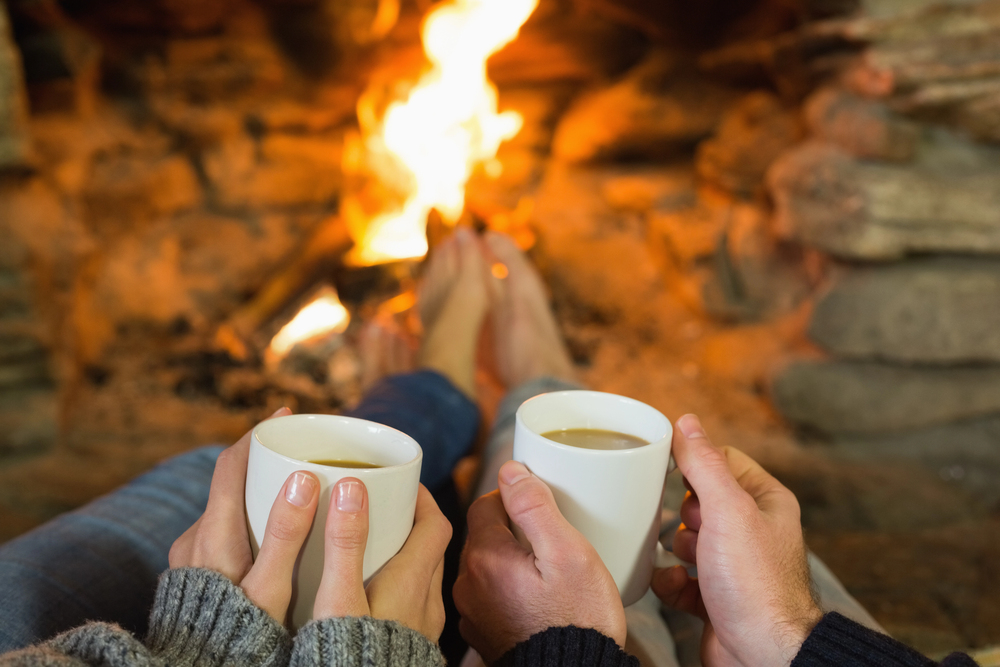 Ambiance cocooning devant la cheminée avec boissons chaudes, symbole de confort et bien-être chez soi