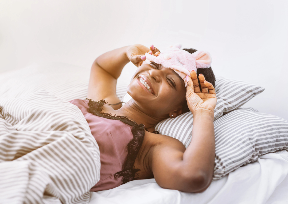 Femme reposée dans son lit, moment de réconfort et de douceur chez soi