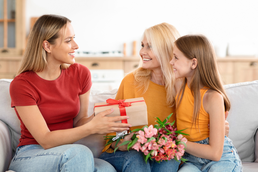 Enfant et maman offrant un cadeau à sa mère pour la fête des mères, moment d’émotion et de complicité