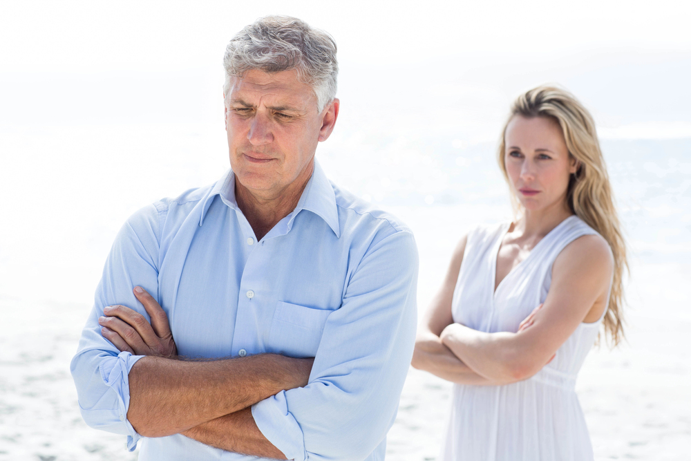Homme de 40 ans distant de dos à une femme contrariée dans une relation de couple compliquée
