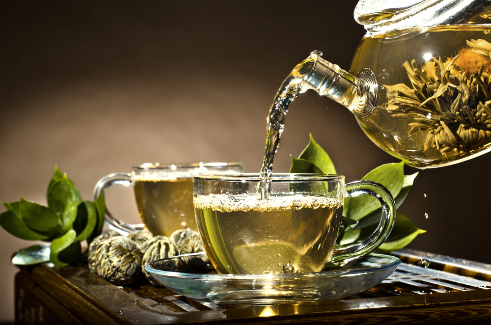 Tisane de thé vert versée dans une tasse en verre, source naturelle de L-théanine pour une concentration calme et durable