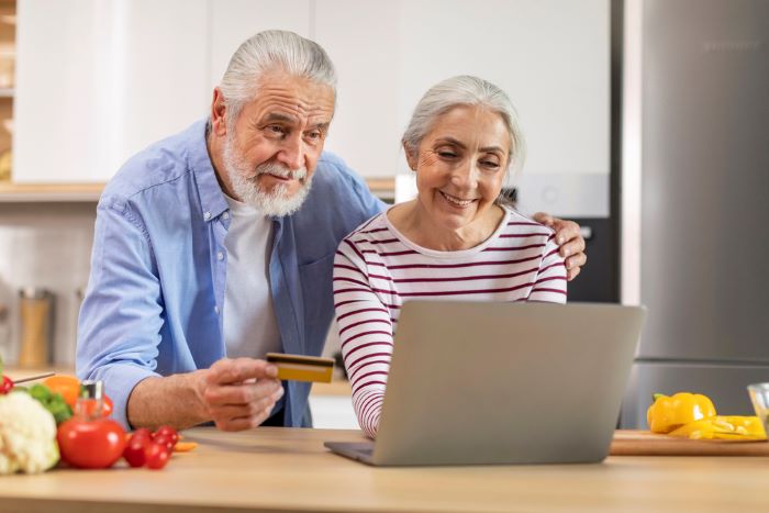 Un couple de personnes agees qui font une commande dans un supermarche en ligne 