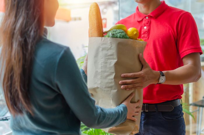 Une femme qui recoit sa livraison du supermarche en ligne