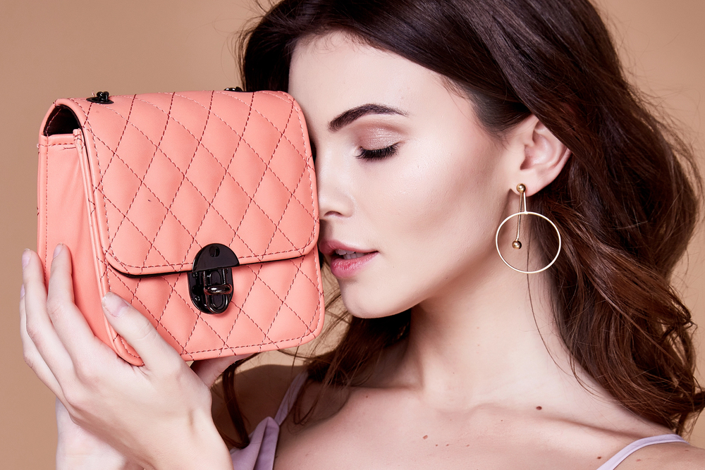 Femme élégante avec un sac à main rose poudré, symbole de coup de cœur mode et d’expression personnelle.