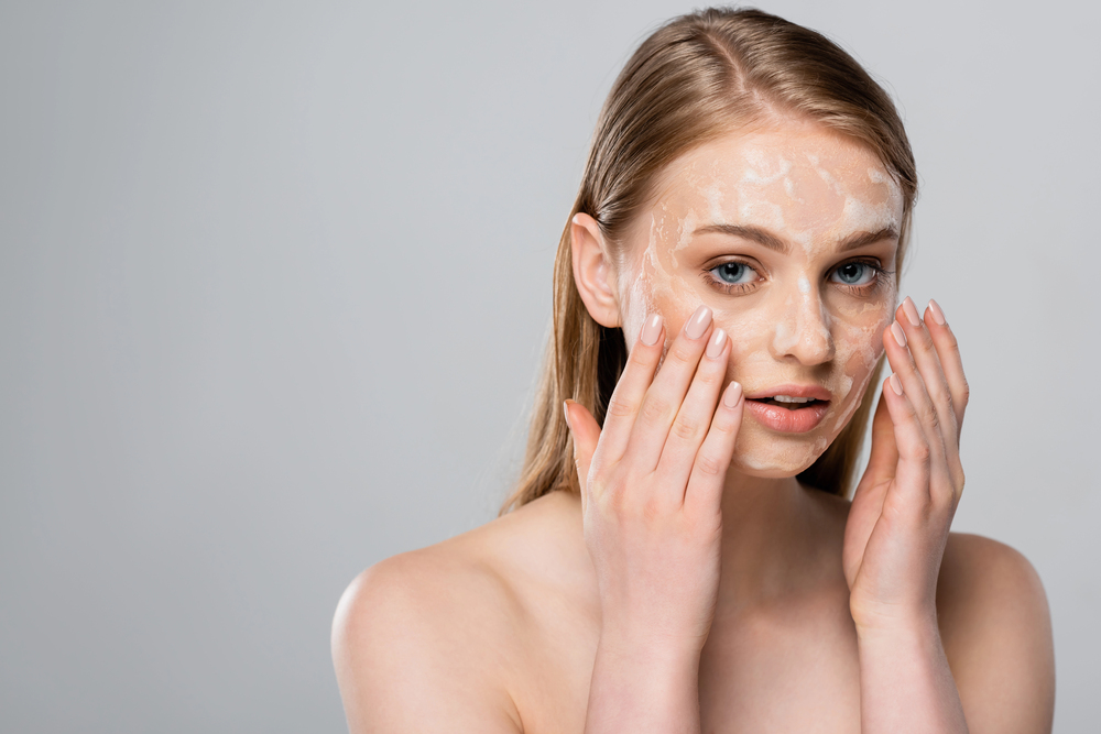 Femme avec des zones de desquamation visibles sur le visage après l’application de maquillage