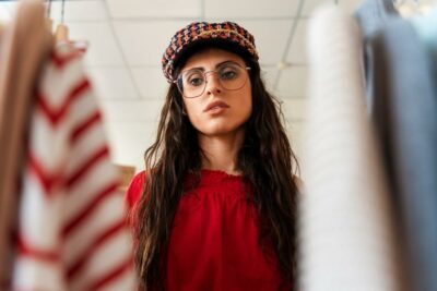 Jeune femme observant des vetements dans une boutique symbole dune consommation de mode plus consciente