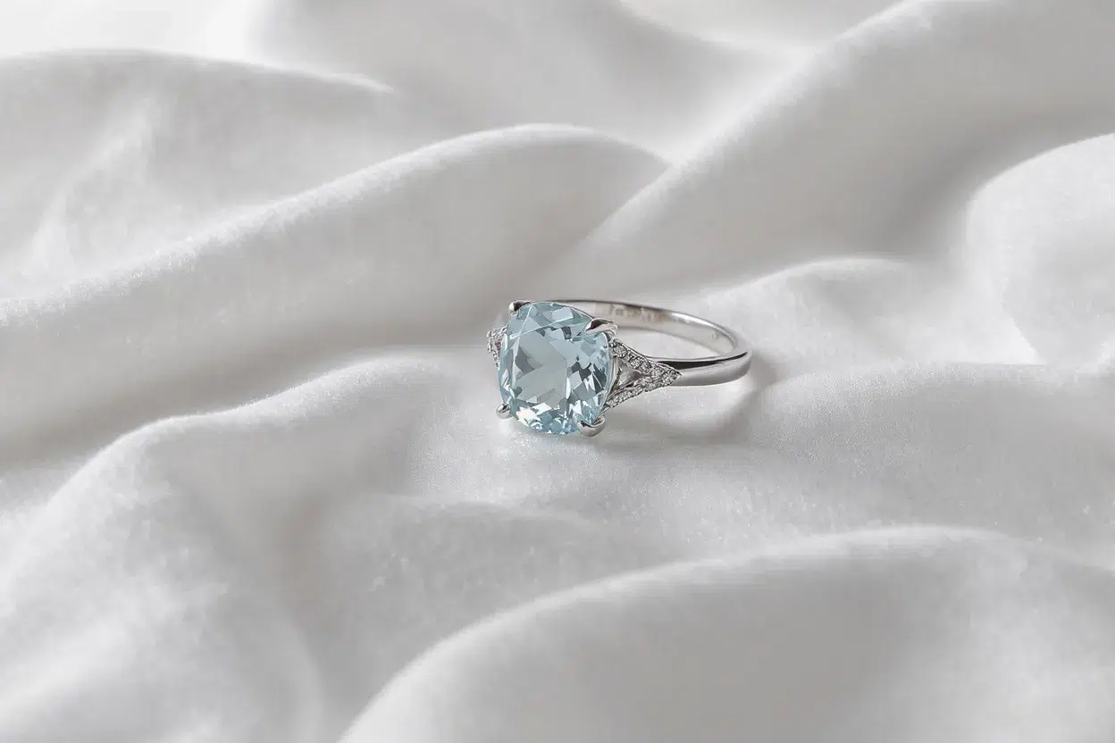 Bague en aigue-marine posée sur une serviette en coton blanc, séchage à l’air libre, ambiance élégante et épurée