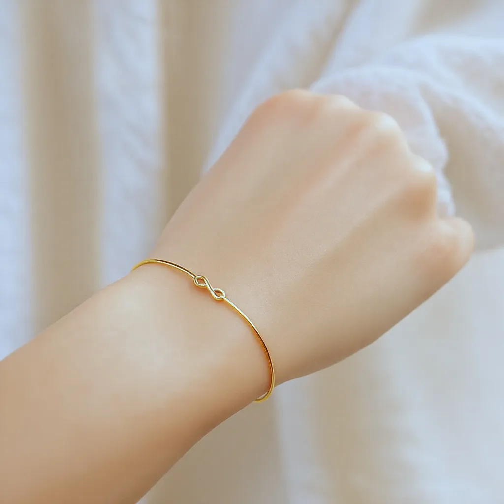 Bracelets fins en or et argent portés par une femme au style minimaliste et élégant.