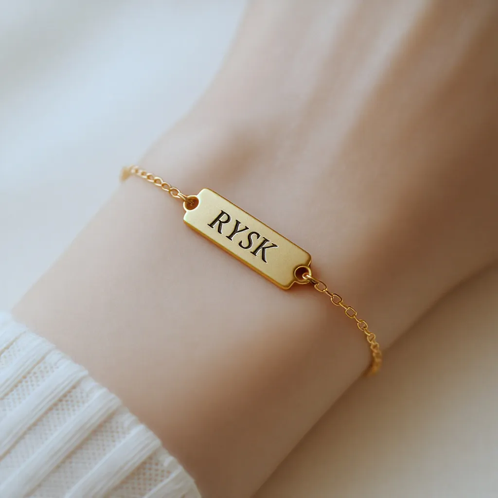 Bracelet en plaqué or avec plaque gravée d’initiales, sur un poignet féminin délicat