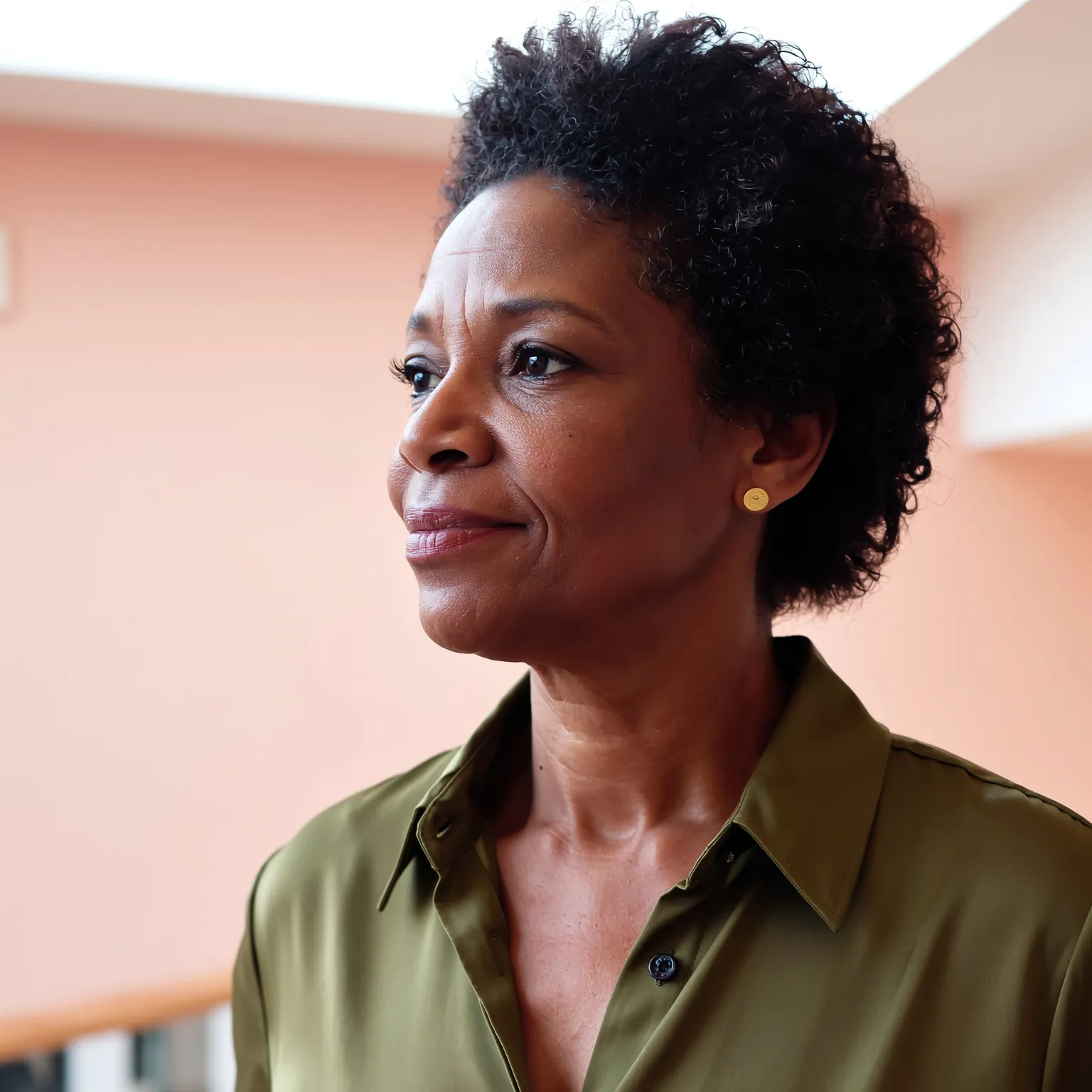 Carré court frisé naturel femme noire 60 ans, coiffure volumineuse élégante et naturelle.