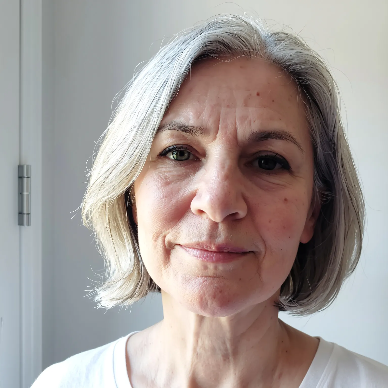 Carré gris en couches douces femme 60 ans, coupe légère et féminine pour cheveux fins argentés.