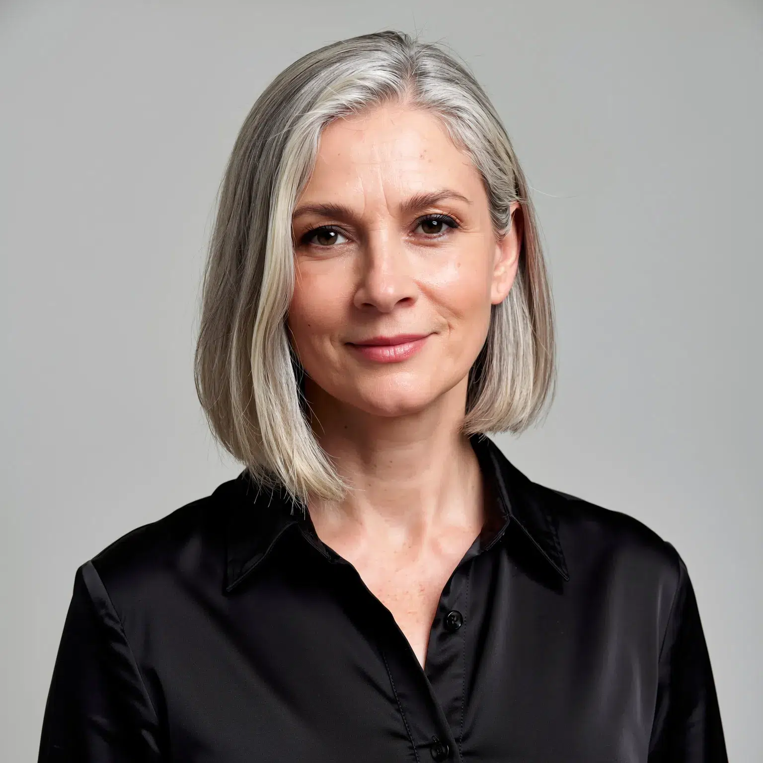 Carré sleek argenté femme 64 ans, coupe lisse élégante et sophistiquée aux reflets métalliques.