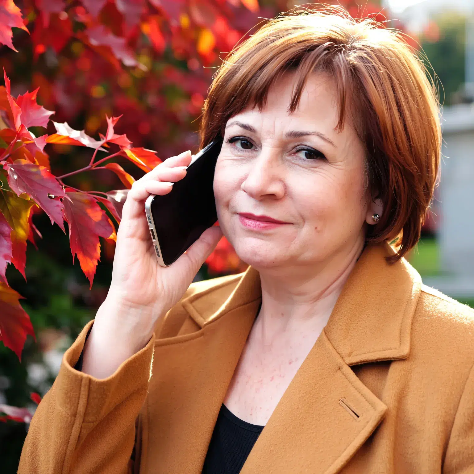 Coupe courte cuivrée femme 60 ans, coiffure chaude et vibrante dans un décor automnal.