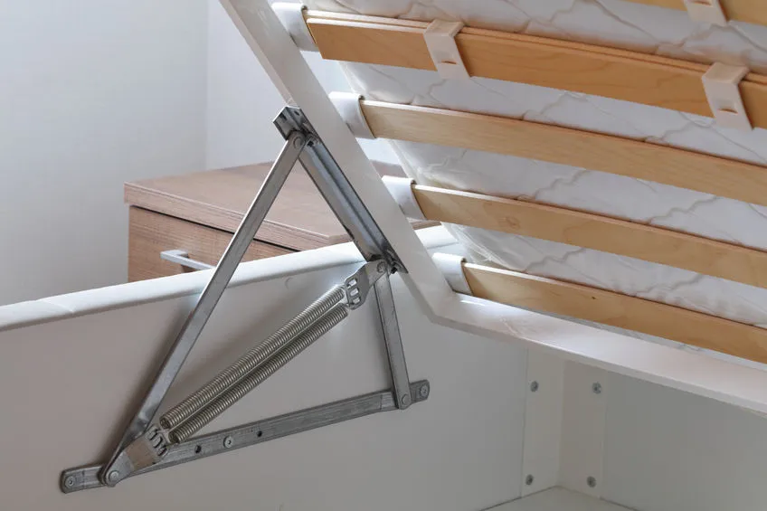 Détail du mécanisme de levage d’un lit coffre en métal, montrant la structure robuste et le rangement intégré sous le sommier.