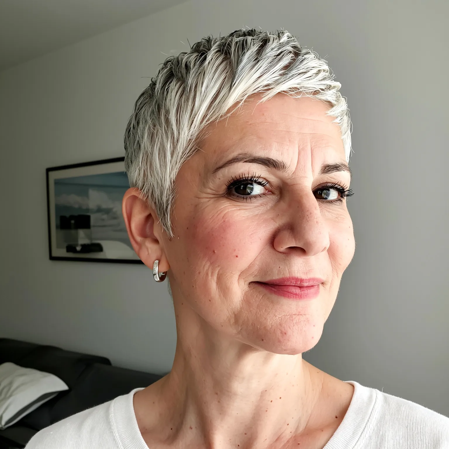 Pixie gris naturel pour femme de 65 ans, coupe courte élégante cheveux argentés sans coloration pour un style affirmé.