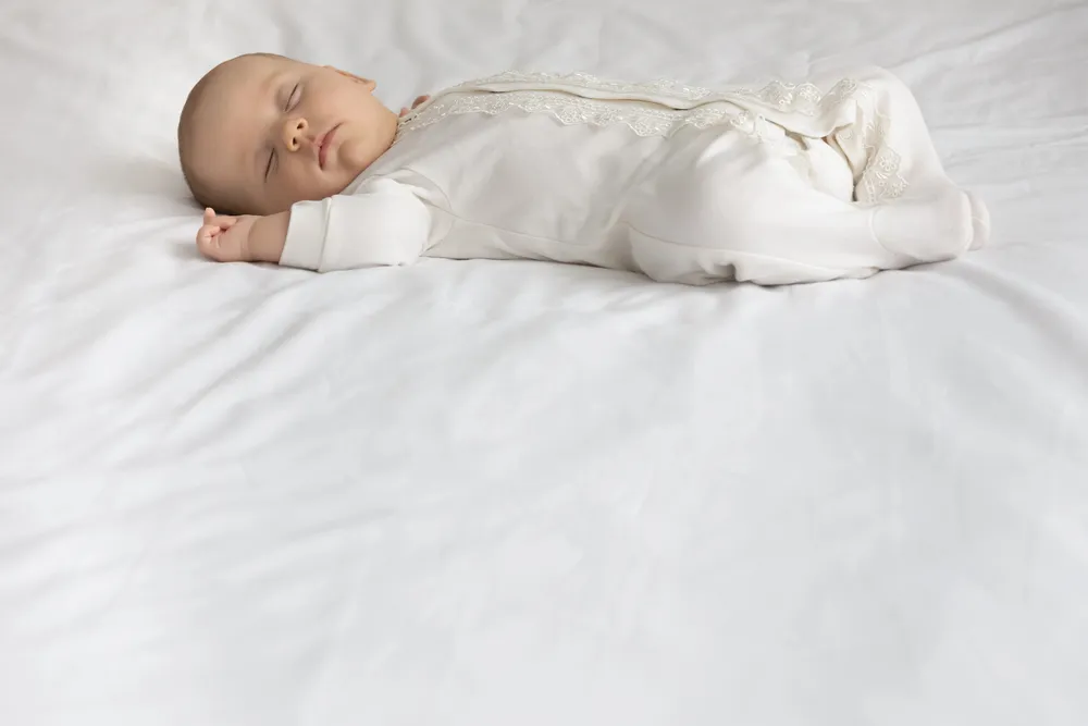 un Bebe en pyjama blanc dors paisiblement sur un bon matelas de qualité