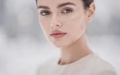 Routine December Skin Reset mise en scène, femme au teint lumineux en lumière douce hivernale, ambiance beauté minimaliste