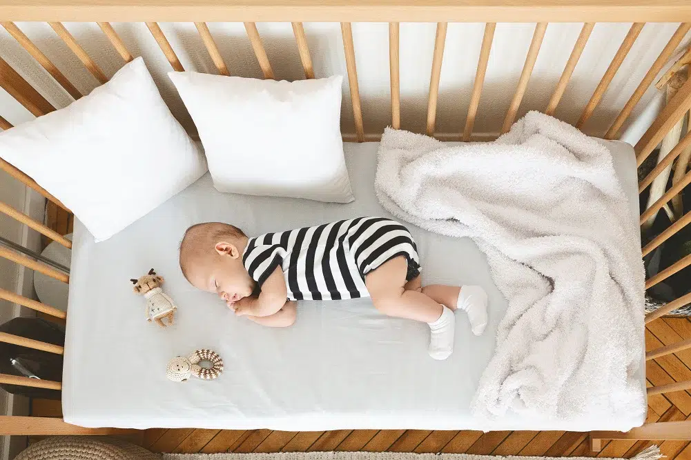 un bébé de 5 mois dors paisiblement dans son lit avec un matelas bien choisi