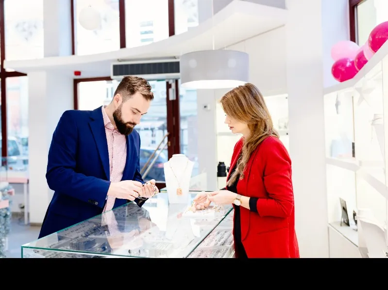 Femme choisit une medaille croix chez un bijoutier