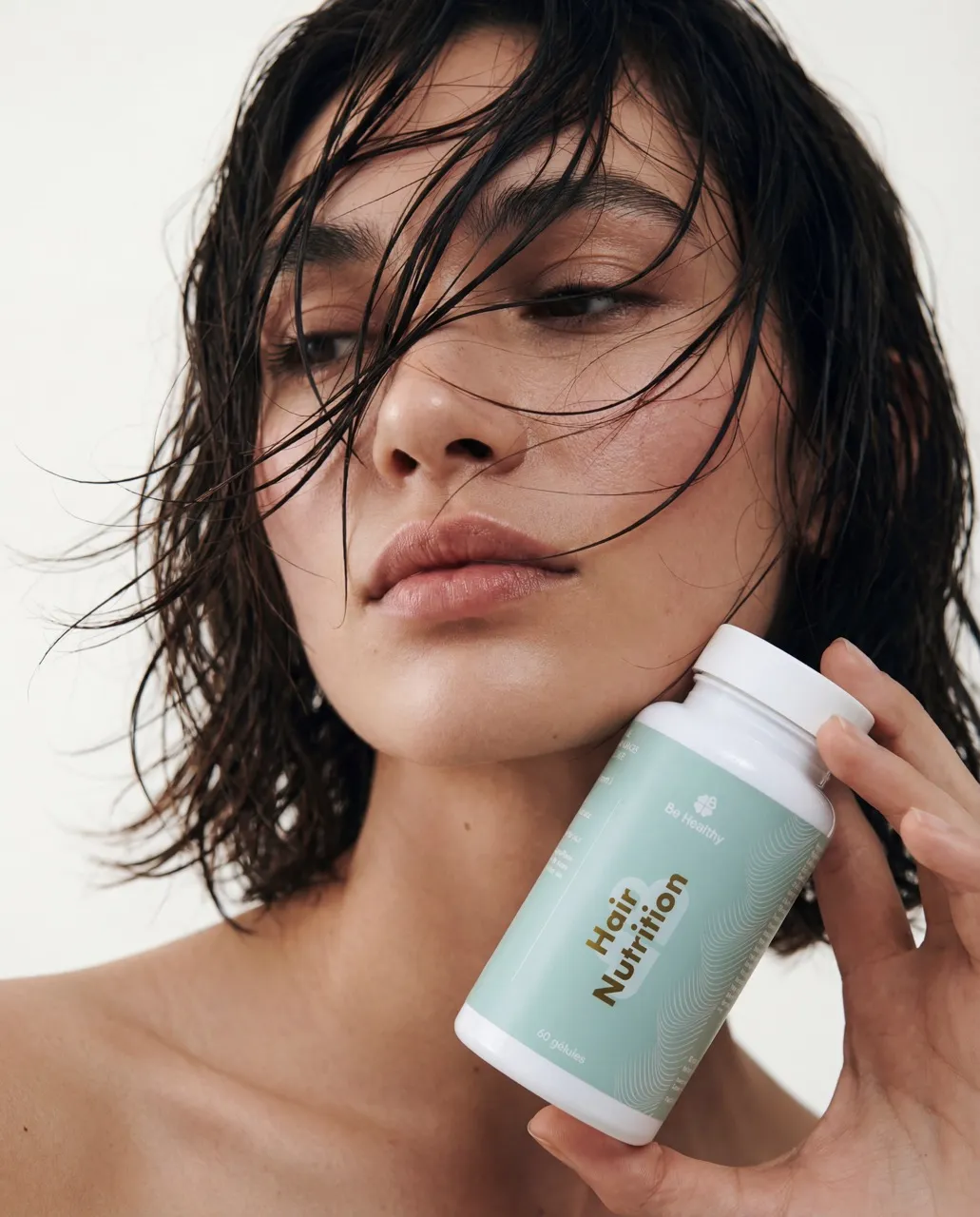 femme aux beaux cheveux tenant une boite de gellules pour une cure de nutricosmétique capillaire 