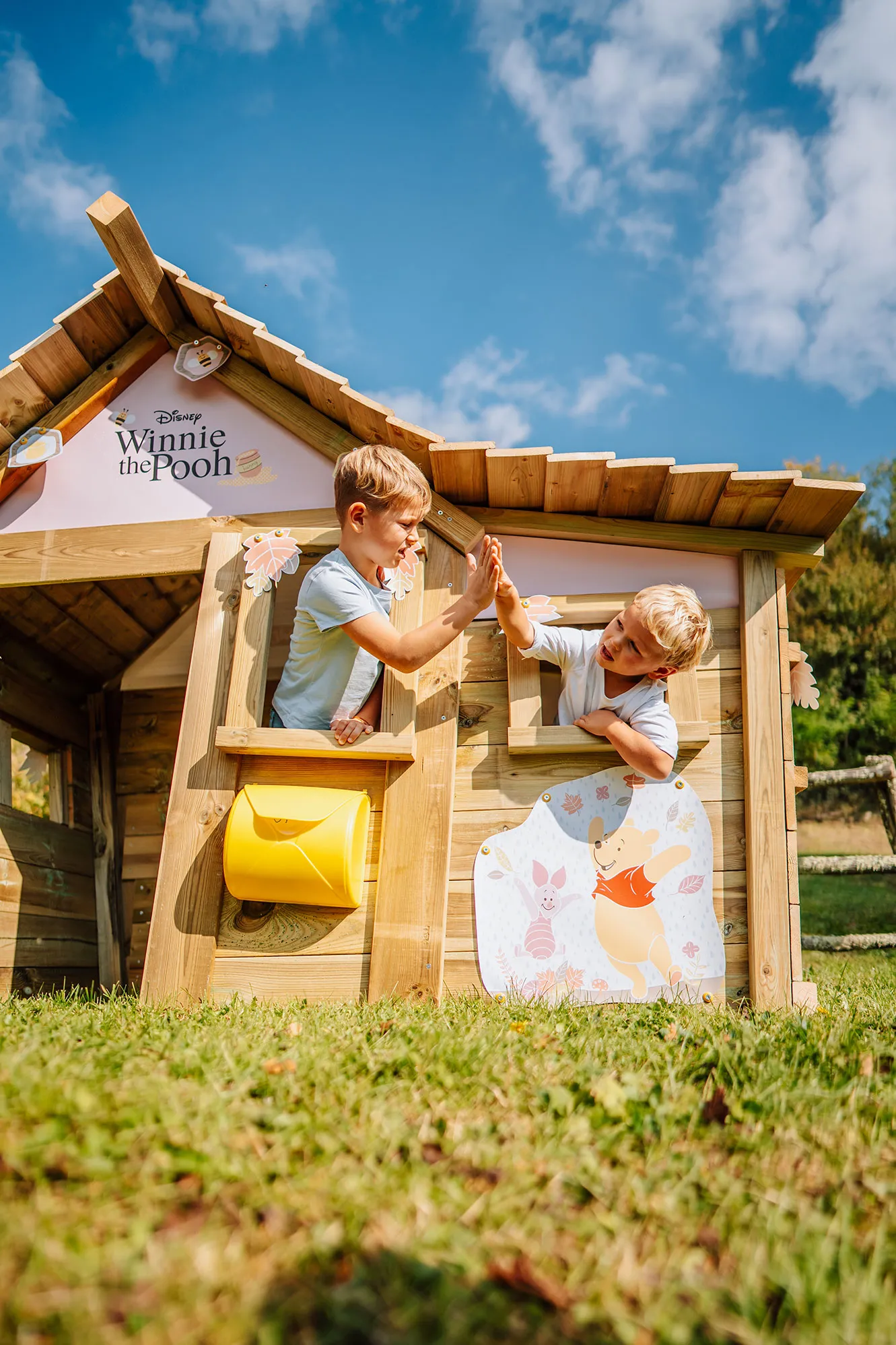 Deux enfants jouant dans une cabane en bois dans le jardin par beau temps