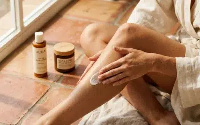 Femme appliquant une lotion hydratante sur ses jambes avant de s'exposer au soleil en été